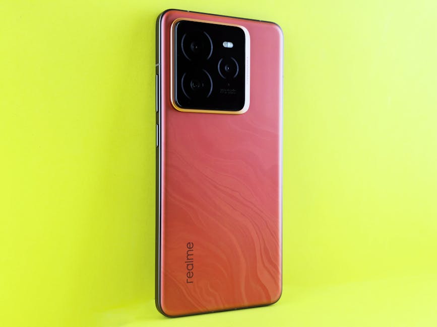 A sleek Realme smartphone with a red finish on a bright yellow background, showcasing the camera module.