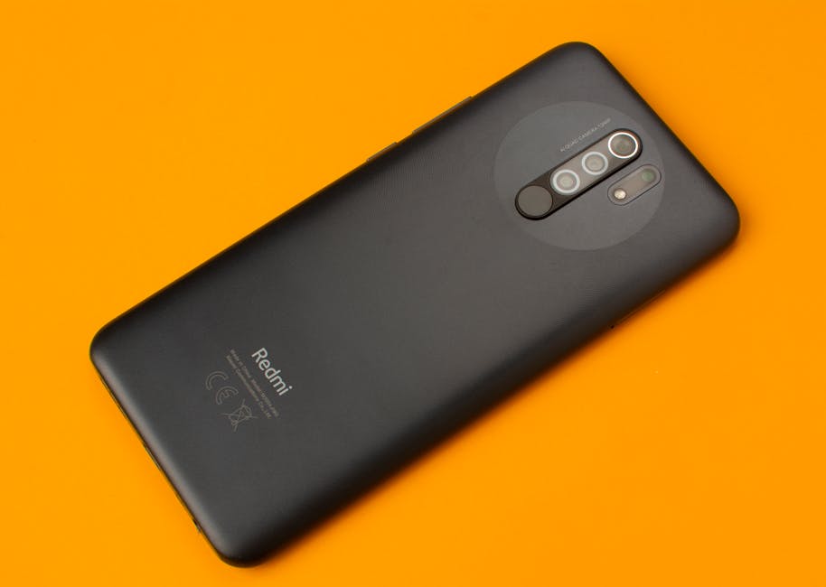 Black smartphone placed on a vivid orange background, showcasing sleek design and multiple cameras.