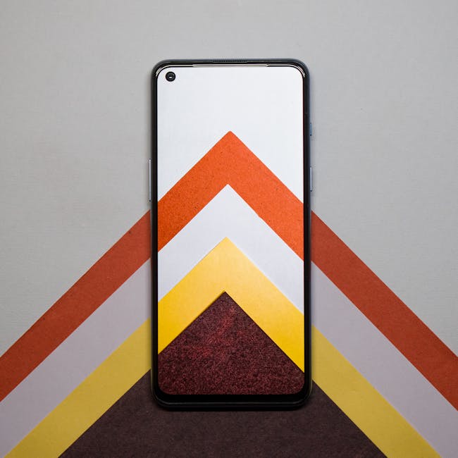 A smartphone placed on colorful geometric pattern papers for a vibrant look.