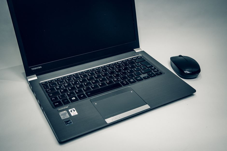 Close-up of a Toshiba laptop with a mouse, perfect for tech and workspace themes.