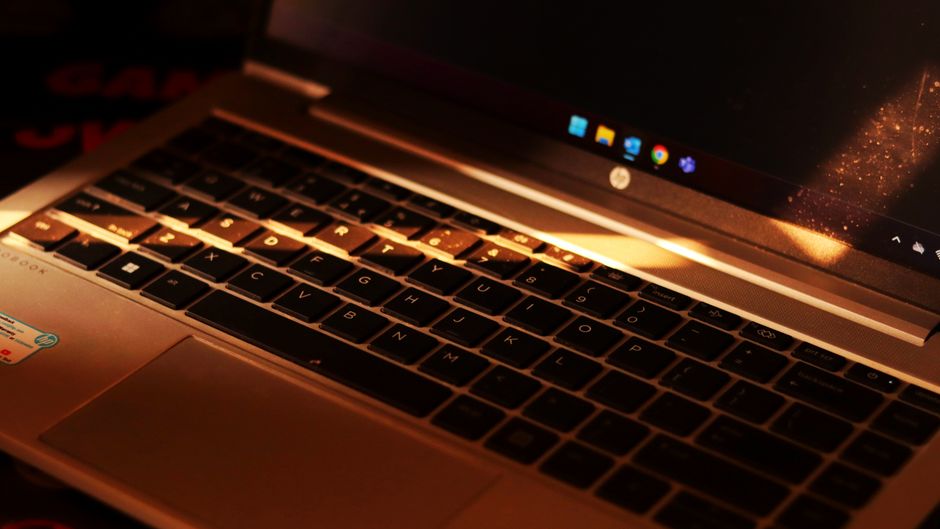Close-up of a laptop keyboard with warm sunlight highlighting the keys.