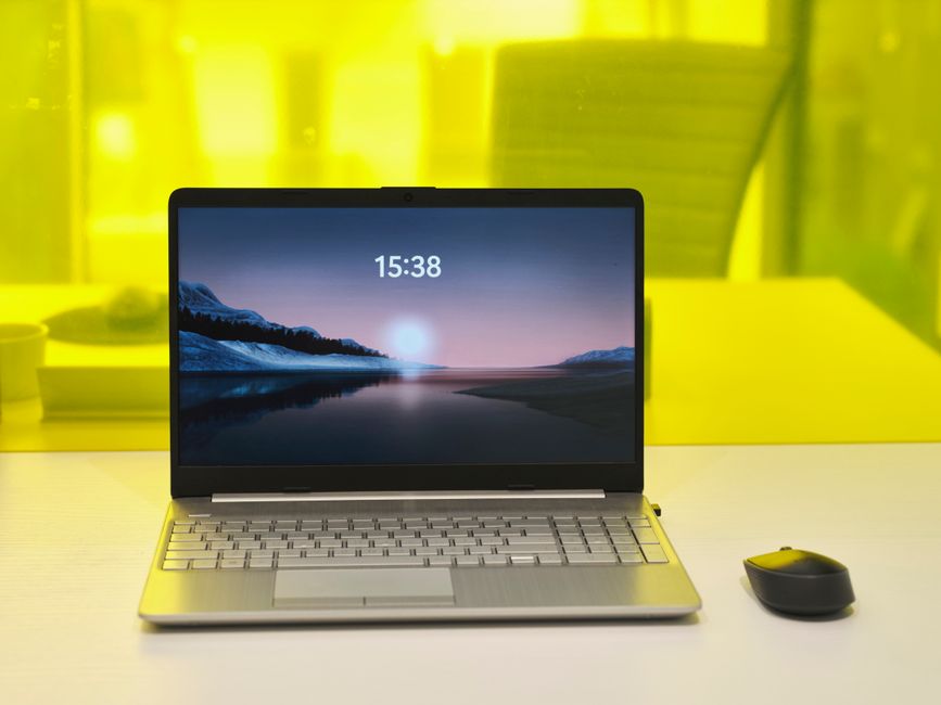 Sleek laptop with a serene nature wallpaper on a desk, highlighting modern technology.